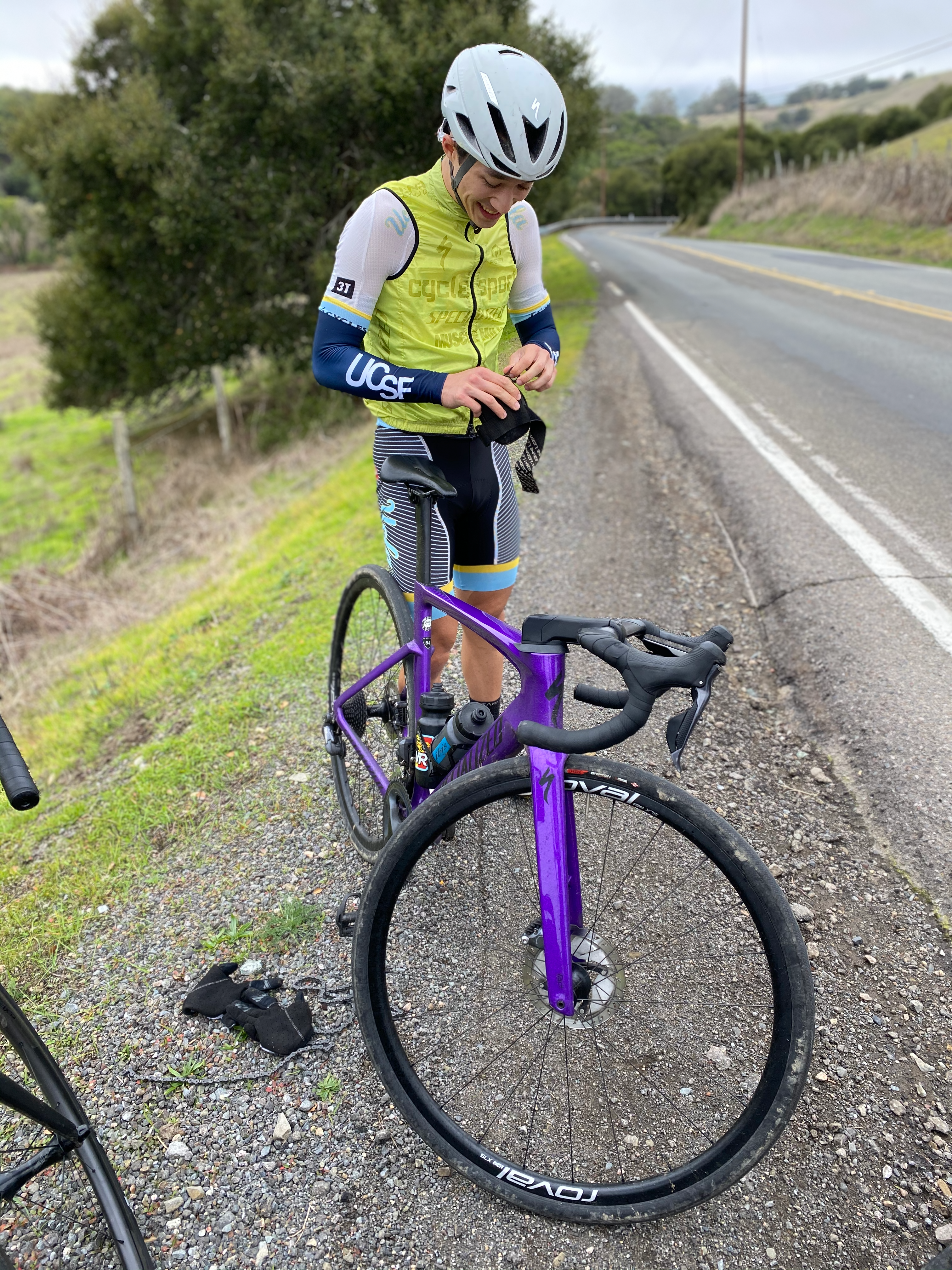 Cyclist fixing chain on the side of the road