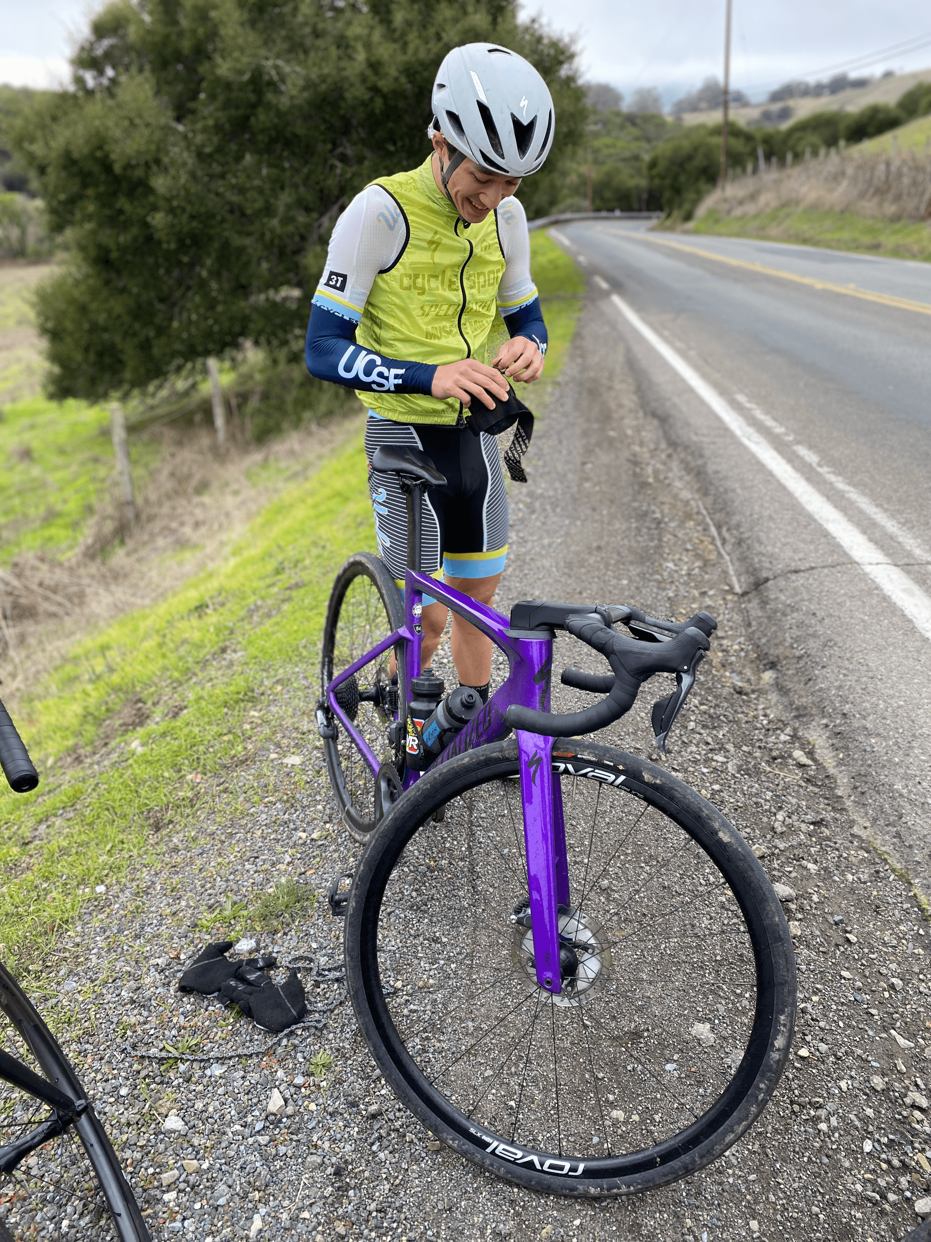 Cyclist fixing chain on the side of the road